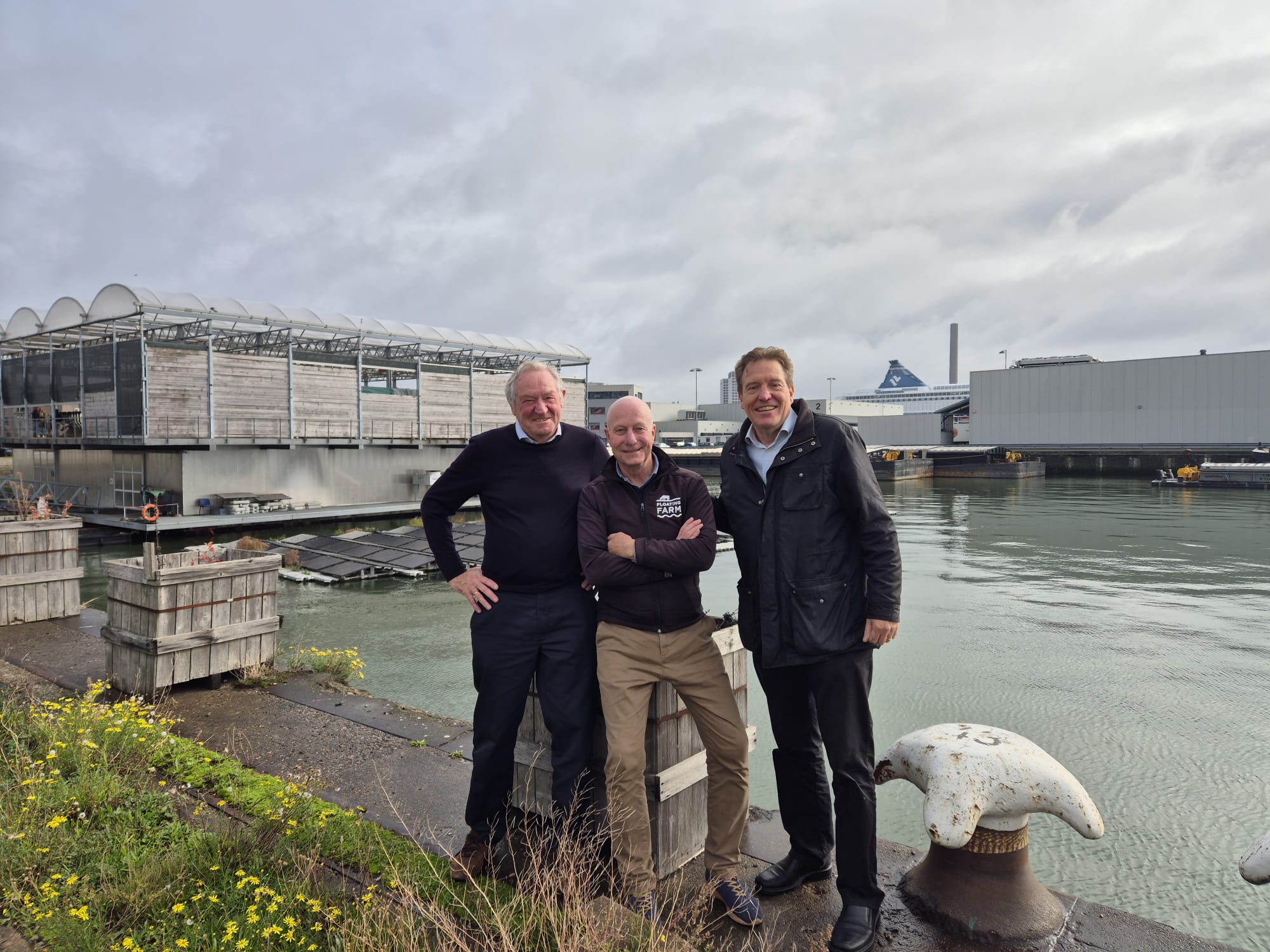 Representatives from Rainmaker Holland, WIC, and Floating Farm standing by the waterfront during their circular water-food collaboration in Rotterdam.